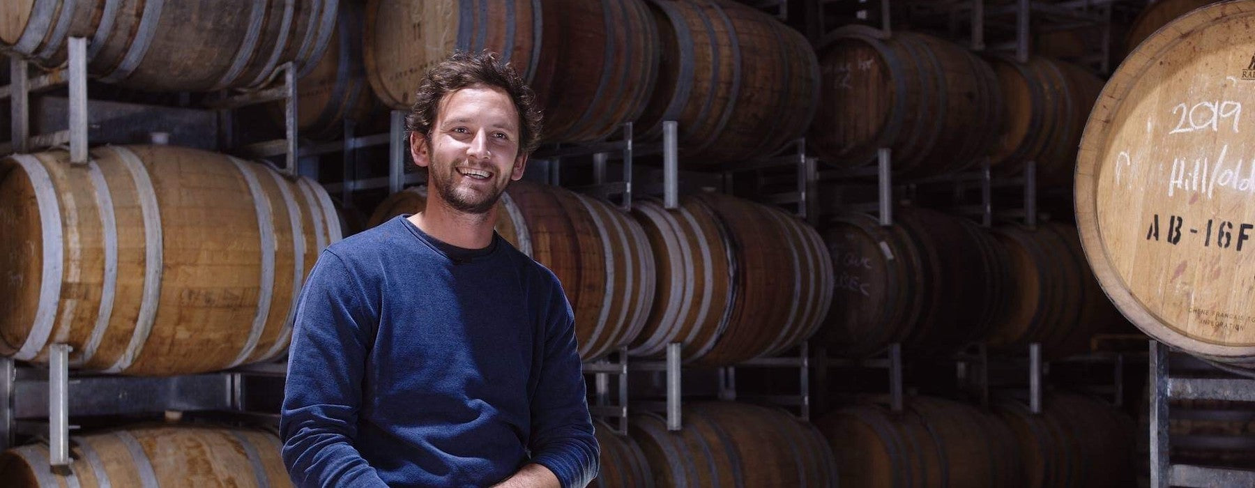 Winemaker Angus Wardlaw surrounded by wine barrels